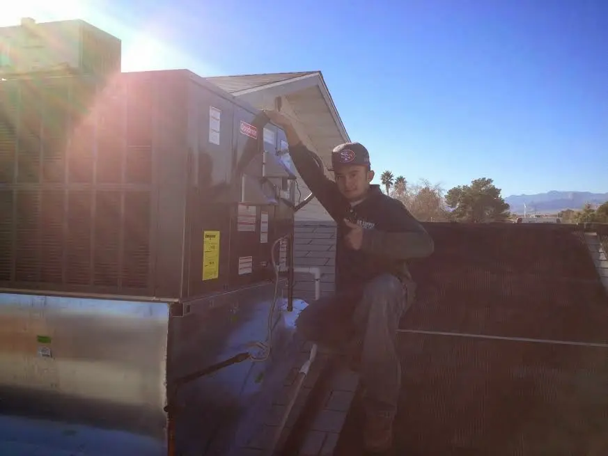 HVAC technician performing Heat Pump Repair on a rooftop unit in Lynbrook